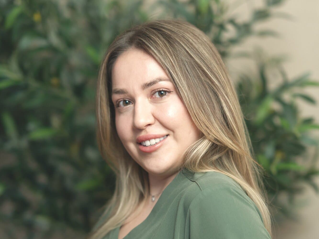 Alina Dreeva, registered nurse and aesthetic injector at éclat Spa & Wellness, in olive scrubs